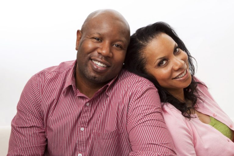 Un couple souriant, appuyé l'un contre l'autre